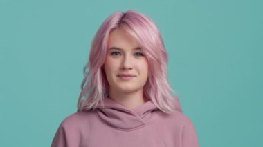 Olumlu gülümseyen genç hippi model seninle aynı fikirde. Moda pastel, pembe saç stili, kapüşonlu, izole bir arka planı olan bir kadın. Sakin öğrenci kızın başını sallaması doğru olduğunu söylüyor.