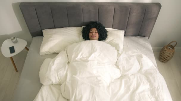 침대에 누워서 행복해 보이는 귀여운 아프리카 미국인 일어나 침대에 카메라 — 비디오