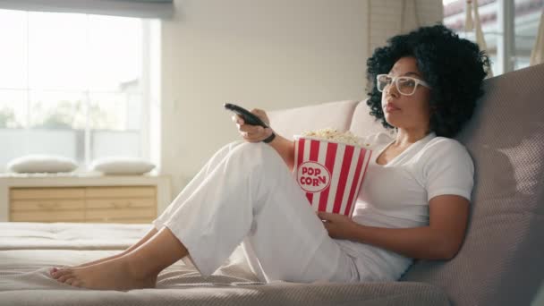 거실에 아프리카 미국인 리모컨으로 채널을 바꾸고 있습니다 여자가 사용하여 오락용으로 — 비디오