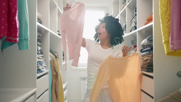 Красивая Молодая Афроамериканка Выбирает Одежду Работы Гардеробе Дома Симпатичная Смешная — стоковое видео