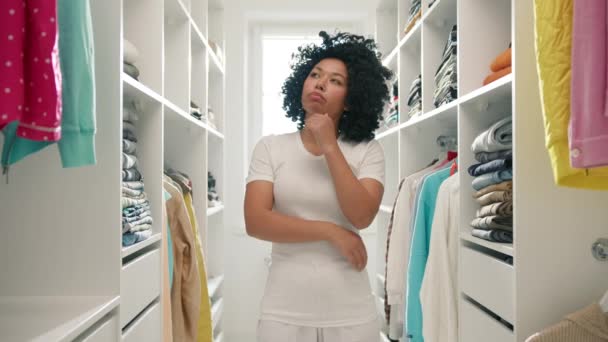 Bedachtzame Jonge Afro Amerikaanse Vrouw Witte Kleren Kijkt Rekken Vol — Stockvideo