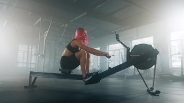 Woman working out for muscle strength and fat burning indoors. Caucasian female athlete using a pedal exerciser at the gym. High quality 4k footage