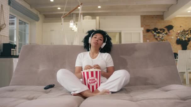 Calm Young African American Woman Using Headphone While Sitting Couch — Vídeo de Stock