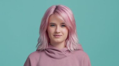 Cunning girl with pink hair plotting insidious plan or travel idea. Thinks through the details with thoughts boiling in head. Woman 20s make choice. Positive smiling emotional woman on blue background