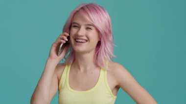 Smiling young business woman professional talking phone. Happy female entrepreneur with beautiful pastel pink hair make mobile call confirming online website order. Customer shopping delivery concept