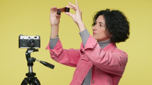 Fotografer Memegang Ulasan Negatif Film Latar Belakang Studio Dengan Kamera — Stok Video