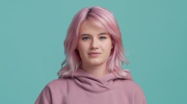 Unhappy young woman giving thumbs down gesture after cut throat move. Portrait of unsatisfied hipster student girl in hoodie sweater showing you have a problem in education or parents, relationships
