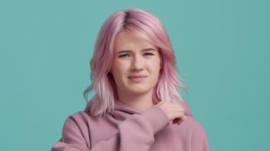 Portrait of unsatisfied hipster student girl in hoodie sweater showing you have a problem in education or parents, relationships. Unhappy young woman giving thumbs down gesture after cut throat move