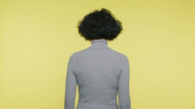 Rear view of mature woman 40s turning back and looking in camera surprisingly with smile. Positive face expression of adult woman saying WOW look what is here, good to see you slow motion 4K studio