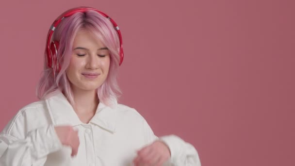 Young Woman Pink Hair Wearing Modern Red Headphones Pointing Empty — Stockvideo