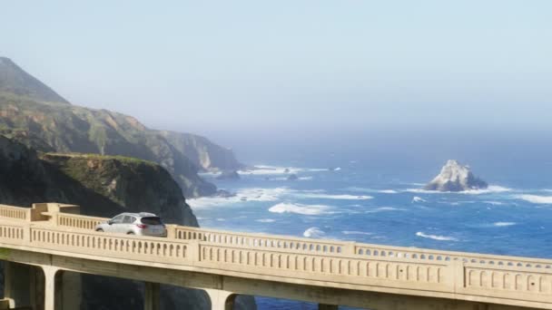 世界的に有名なBixbyブリッジ4KがRedカメラで撮影したSuv車の運転のショットに続くシネマティック 風光明媚な旅行のためのロードトリップコンセプト映像コピースペース カリフォルニア州での休暇中の西海岸観光米国 — ストック動画