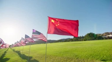 Flag of China waving wind with many American flags on motion background, golden sunset hour with sun flare. National Chinese flag visualizing independence, freedom, economy partnership business 4K