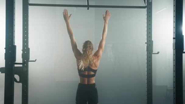 献身的な女性は彼女の筋肉を強化するためにあごのアップを実行します ジムでの朝のワークアウトセッション中の白人のフィットネスガールのバックビュー 高品質4K映像 — ストック動画