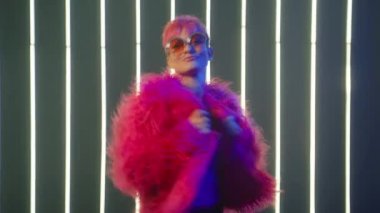 Happy Laughter Trendy Female Listen Music and Dance in Night club neon lights. Young Girl with bright pink hair raising and waving arms in dancing moves. People Energy celebrating New Year Slow Motion