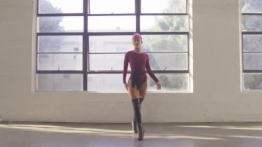 Attractive talented woman dancing sensual sexy moves on studio windows background. Shooting modern choreography for advertising of dance school, dancer expressing feelings for music video performance