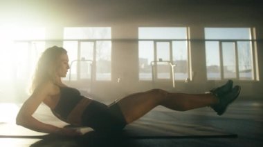 Close-up view of healthy, active woman training her abs muscles in modern gym studio. Portrait of sporty, young lady in her 30s building strong, fit body. High quality 4k footage