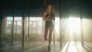 Close-up view of caucasian sportswoman squatting on one leg to build lean muscles. Young, blonde-haired lady shaping up her legs and butt in modern gym studio. High quality 4k footage