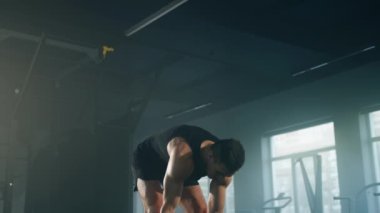 Close-up shot of athlete lifting a barbell with both hands to build muscles. Portrait of a man with muscular body training his arms with heavy weights. High quality 4k footage