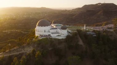 Hollywood Dağı 'ndaki Griffith Gözlemevi' nin muhteşem manzarası. Kalabalık giriş ve gözlem güvertesi, Los Angeles şehir manzaralı, California. Altın gün batımında güzel bir gökyüzü parıldıyor mercek