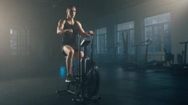 Close-up shot of dedicated sportsman during intensive cardio workout. Portrait of muscular, caucasian man using elliptical machine to boosting his stamina. High quality 4k footage