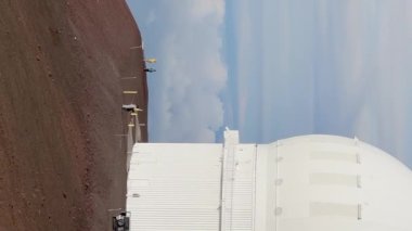 Büyük Ada, Hawaii ABD 'de gün batımında Mauna Kea zirvesinde astronomik teleskopların mobil içeriği için dikey yönelimli. Kırmızı volkanik kraterde uluslararası bilim gözlemevleri olan dağın tepesinde.