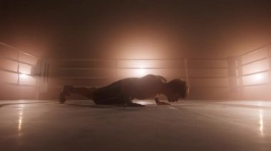 Portrait of a male athlete performing push-ups to stimulate muscle growth. Close-up shot of professional boxer pushing up and clapping behind his back. High quality 4k footage