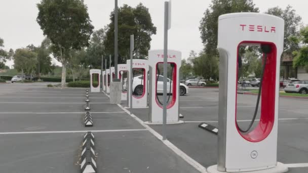 2023年2月7日 ロサンゼルス 排出ゼロのグリーン車のための自動充電器 長い旅のための道路による白いEv車の充電の側のビュー 高品質4K映像 — ストック動画