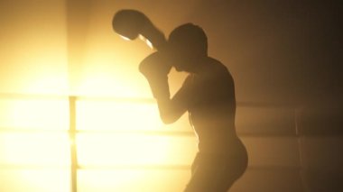 Portrait of professional boxer with shirtless torso warming up in the ring. Close-up view of caucasian man in boxing gloves training his punch before a match. High quality 4k footage
