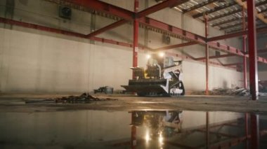 01 Şubat 2023. California, ABD. Depoda çalışan ağır makineler. Fabrika ticari deposunda çalışan kompakt, sarı pist yükleyicisi. Yüksek kalite 4k görüntü