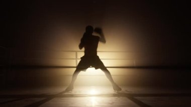 Portrait of unrecognizable male athlete warming up before a sparring. Close-up shot of a sportsman in boxing gloves training in the boxing club to burn calories. High quality 4k footage