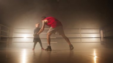 Close-up view of focused kid training with his father. Little boy working out with experienced coach to perform at competitions. High quality 4k footage