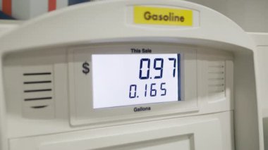 Yakıt ticareti kavramında ciddi fiyatlar yükseliyor, yaşam maliyetini artırıyor. Benzin istasyonunda para ve galon miktarını gösteren yakın çekim görüntüsü. Yüksek kalite 4k görüntü