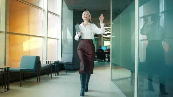 オフィスの廊下で踊る面白い成熟したビジネスマンの女性を動機付け 金曜日の企業パーティーで成功を祝い 幸せなフレンドリーなマネージャー50は 空のオフィスで一人で楽しみ 勝利の散歩を楽しんで4K — ストック動画
