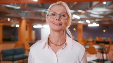 Positive caucasian confident woman in stylish eyewear looking at camera, holding conversation with business client online. Pleasant smart female answering on partners questions at video call meeting