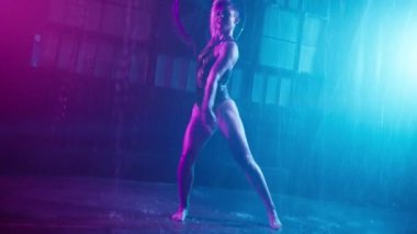 Slow motion beautiful sexy woman dancing, posing and flirting inside dark rain studio. Sensual scene of female model doing different sexy movements.Female model in wet bodysuit in cyberpunk strip club