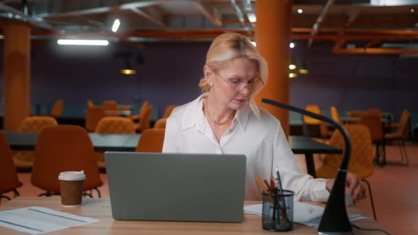 成熟而有思想的女企业家领袖用笔记本电脑在办公室桌上思考公司未来的成功计划 完成项目 关闭笔记本电脑 离开现代公司 — 图库视频影像