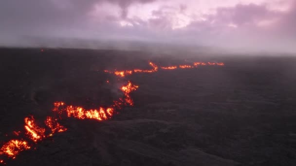 壮大な映画の空中ショット風光明媚なピンクの夕日で熱い赤い溶岩の流れ 空を覆う紫色のライラック雲 熱帯ハワイ島の冒険の黒い凍結した溶岩フィールドの上で美しく蒸発する煙 — ストック動画