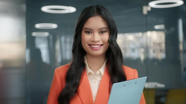 笑容可亲的亚洲年轻女子穿着现代的正式服装 期待着在办公室里拍照 美丽的千禧企业家感到快乐 女商人的肖像动作缓慢 漂亮的商业经理 — 图库视频影像