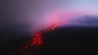 Pembe günbatımının destansı havası ve mor lav akışının üzerinde bulutlar. Aktif volkan patlamasında muhteşem lav nehri. Mauna Loa yanardağındaki Kilauea Ulusal Parkı 'nda yanan sıcak kırmızı lav toprağı.