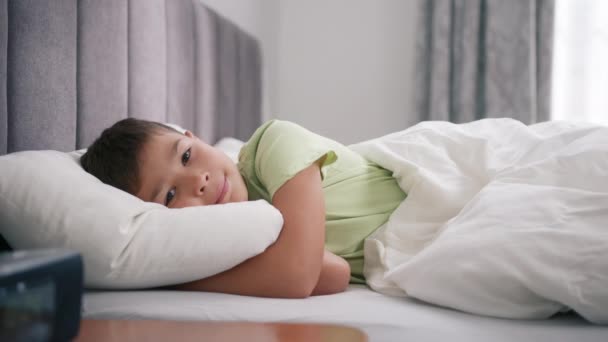 침대에 미소짓고 베개를 껴안는다 시절의 아이들의 침대에서 일어나는 행복하고 귀여운 — 비디오