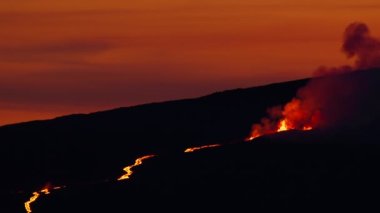 Hawaii 'deki Mauna Loa volkanik patlamasında kaynağından akan erimiş lav nehrinin kanlı turuncu günbatımı gökyüzünde dramatik manzarası. Parlak kırmızı lav kırmızısı kamera manzarası