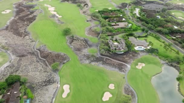 ビッグアイランドハワイ 米国夏の観光で緑のゴルフコースの空中ビュー 白い砂のトラップと緑の草や木 無人機はゴルフコースと高価なリゾートホテルの上を飛ぶ Usa — ストック動画