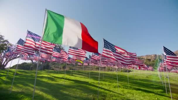 意大利国旗在风中飘扬 许多美国国旗在金色日落时带着太阳耀斑在运动背景下飘扬 展示独立 金融经济 商业伙伴关系的意大利国旗 — 图库视频影像