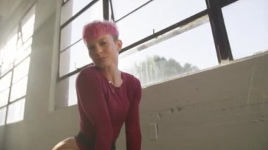 Modern parlak stüdyo arka planında seksi hareketler yapan ve yerde sicim gösteren profesyonel bir dansçı. Müzik klibi stüdyosu çekim yapıyor. Seksi pop ve blues çekimleri RnB video dans sahnesi 4K