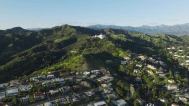 Los Angeles Hollywood Hills 'te büyük lüks villalar ve evler. Güneşli bahar gününde Los Feliz Mahallesi Havalimanı Griffith Parkı ve Yeşil Tepeler 4K 'da görülen Gözlemevi