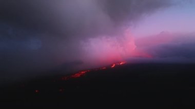 Şiddetli yağmur bulutları ile güzel gökyüzü sinematik kırmızı gün batımını ya da Hawaii 'deki Büyük Ada' nın vahşi doğasında gün doğumunu yansıtıyor. Destansı hava manzarası, kızıl, parlak lav nehri ile volkan püskürtüyor.