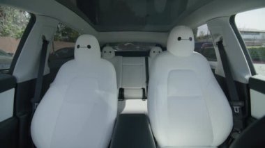 Calabasas, Los Angeles, ABD Mart 2023 sahibi uzaktan kumandayı kullanırken, çevre dostu modern elektrikli arabalarda sürüş teknolojisi çağırır. Tren yapay zeka sürücüsü sistem araçlarını izliyor