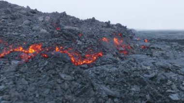 2022 'de Hawaii, Büyük Ada' da Mauna Loa volkanı patlamasının kızgın lav akışı. Turuncu lavların üzerinde uçan hava aracı magma akışı ve siyah dağda donma.
