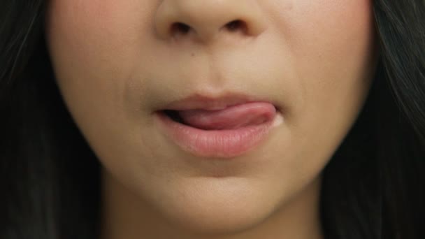 年轻女人面对着咬性感的嘴唇和舔舌头 迷人的少女嘴唇 健康的肌肤妆容 性感女人慢动作地舔着丰满的嘴唇 笑4K — 图库视频影像