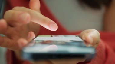 Evdeki akıllı telefon internetini kullanan bir kızın ön görüntüsü. Genç kadınların yakın çekimleri ağır çekimde yapılır. İş kadını telefon mesajı okuyor ya da cep telefonundan indirme uygulamasını arıyor